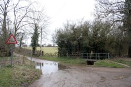 A picture of a muddy ford with trees either side